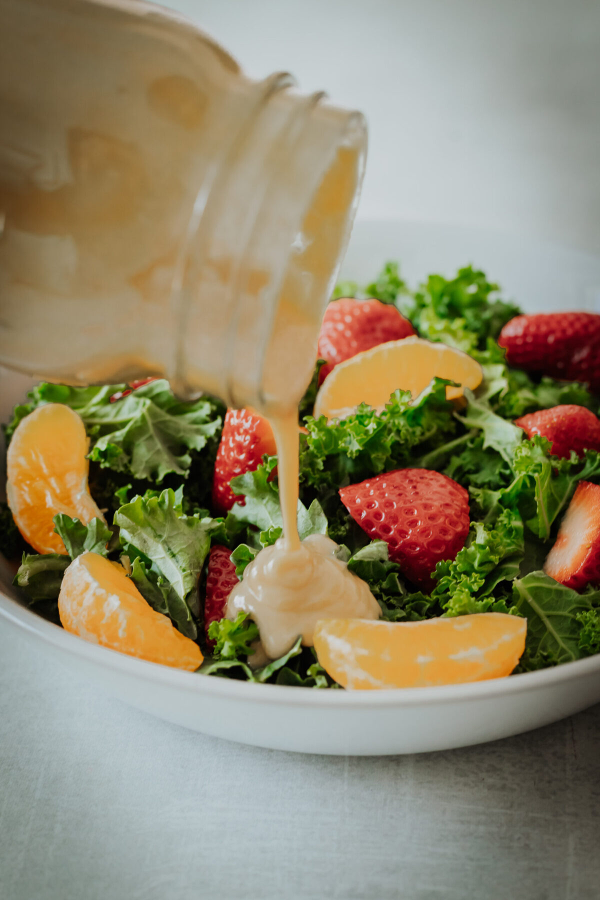 creamy tahini dressing poured on a kale salad