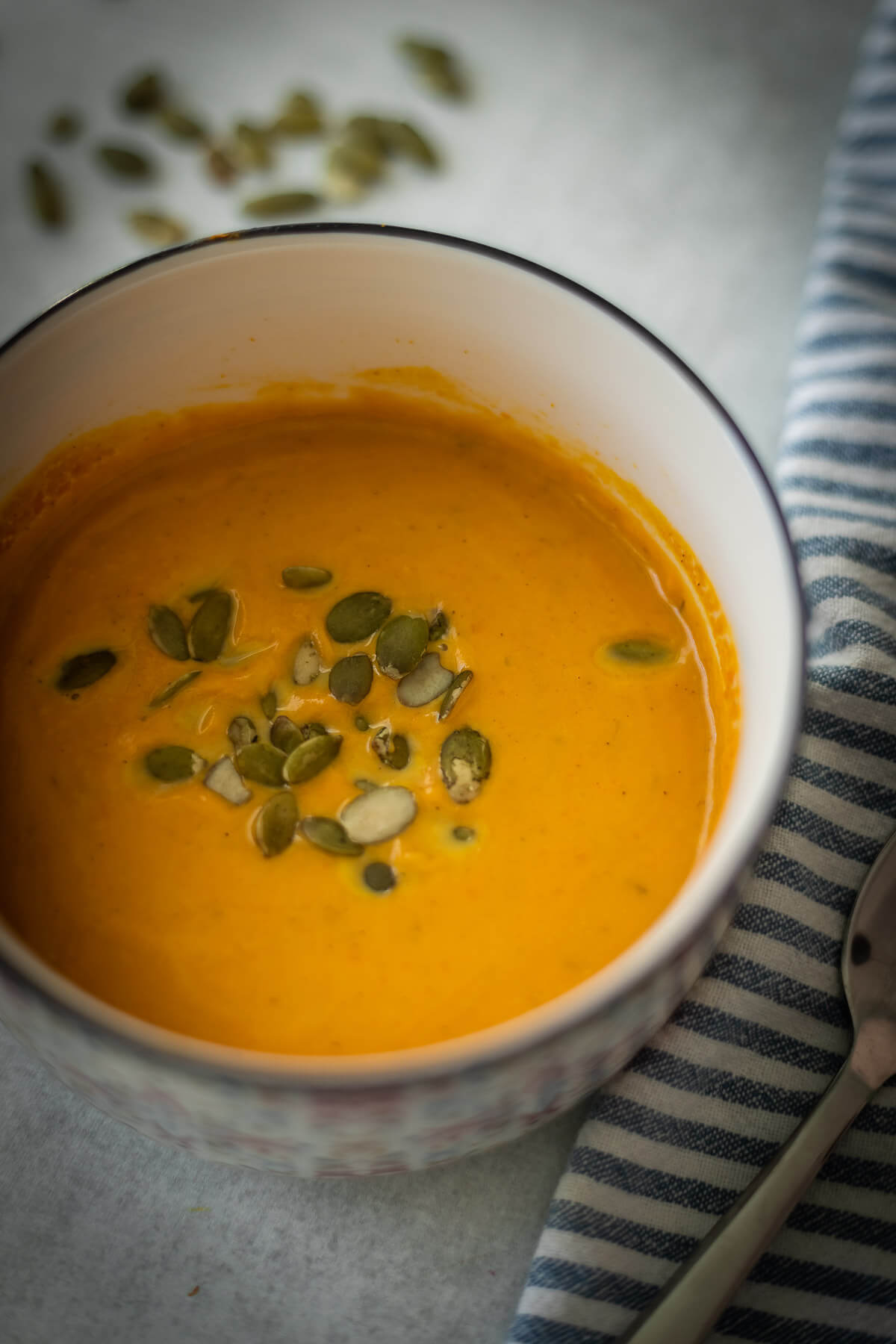 creamy butternut squash soup with pumpkin seeds in a bowl with canned butternut squash