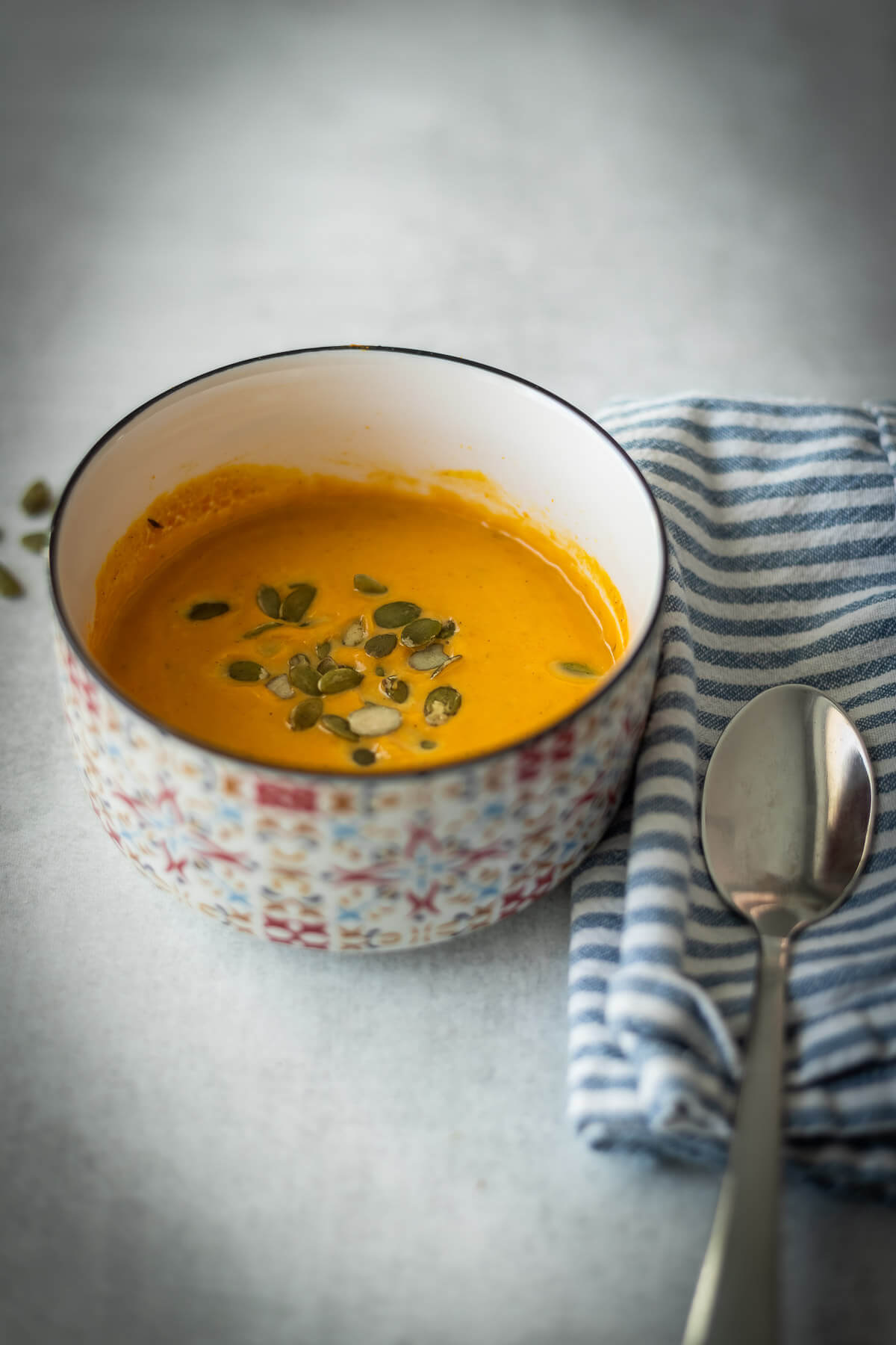 creamy butternut squash soup with pumpkin seeds in a bowl with canned butternut squash