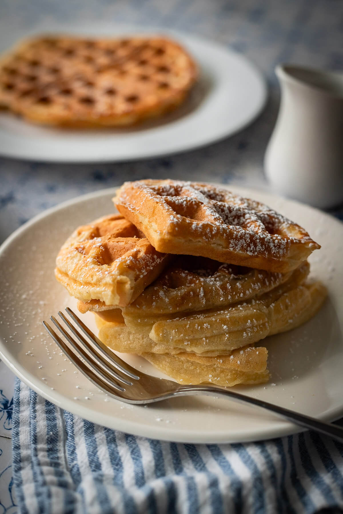 gluten free waffles with powdered sugar and maple syrup
