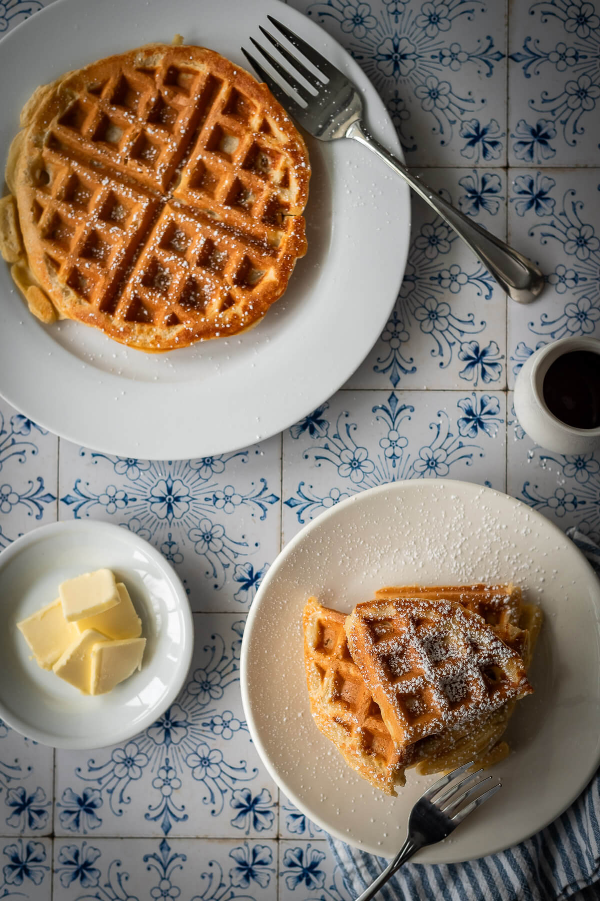 gluten free waffles with powdered sugar syrup and butter on a plate