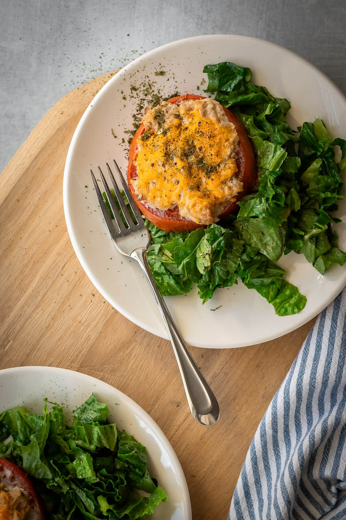 tuna melt tomatoes on a plate with a side salad