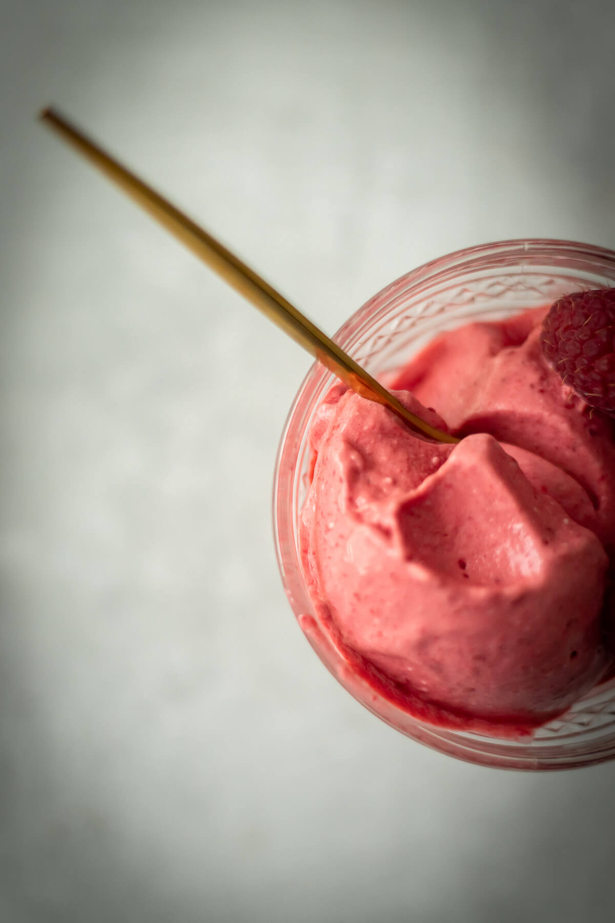 3 ingredient raspberry ice cream in a bowl with a gold spoon