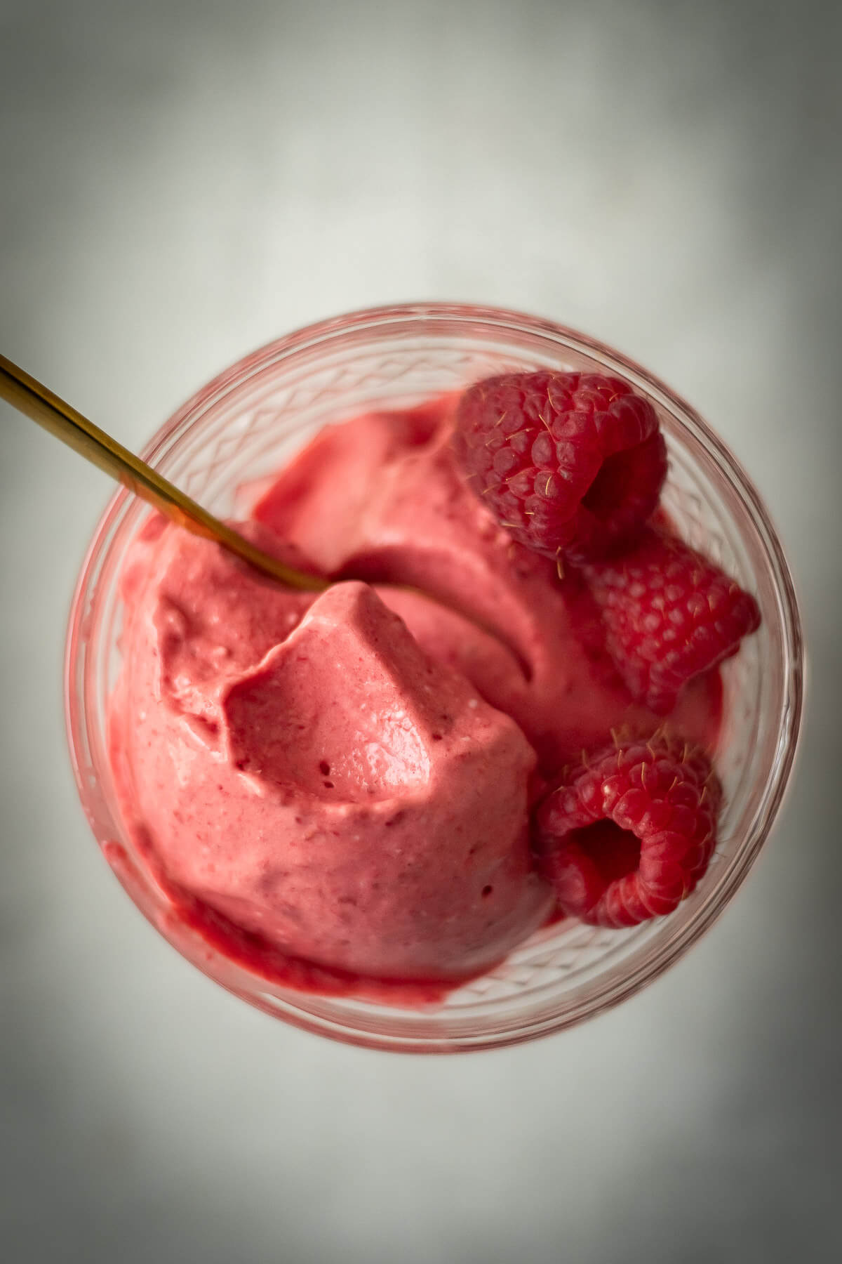 3 ingredient raspberry ice cream in a bowl with a gold spoon