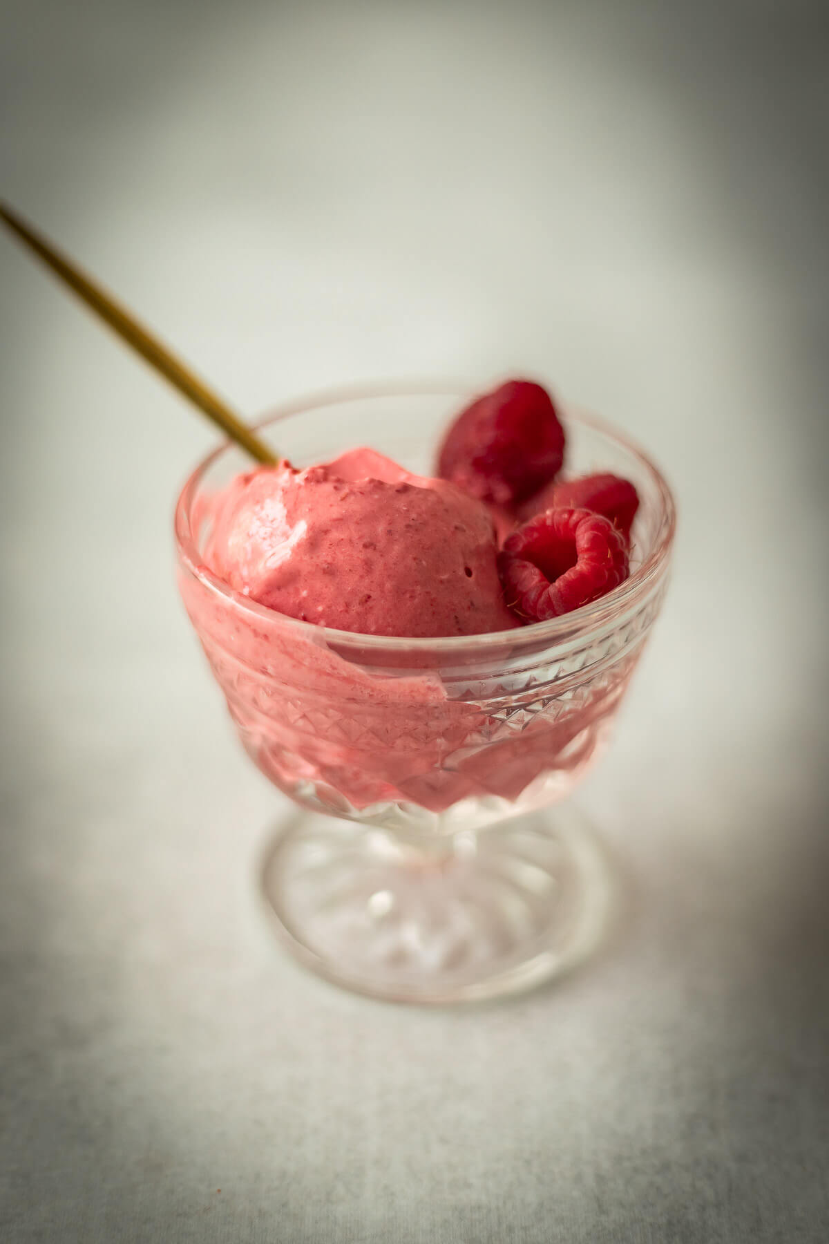3 ingredient raspberry ice cream in a bowl with a gold spoon