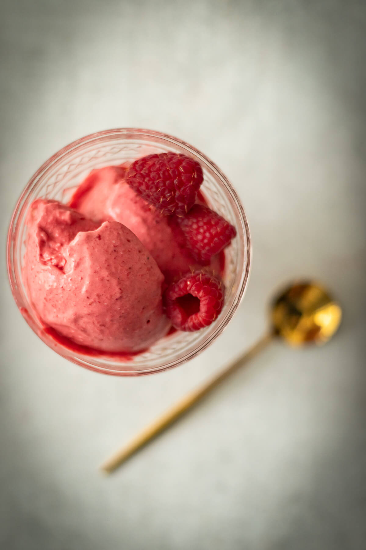 3 ingredient raspberry ice cream in a bowl with a gold spoon