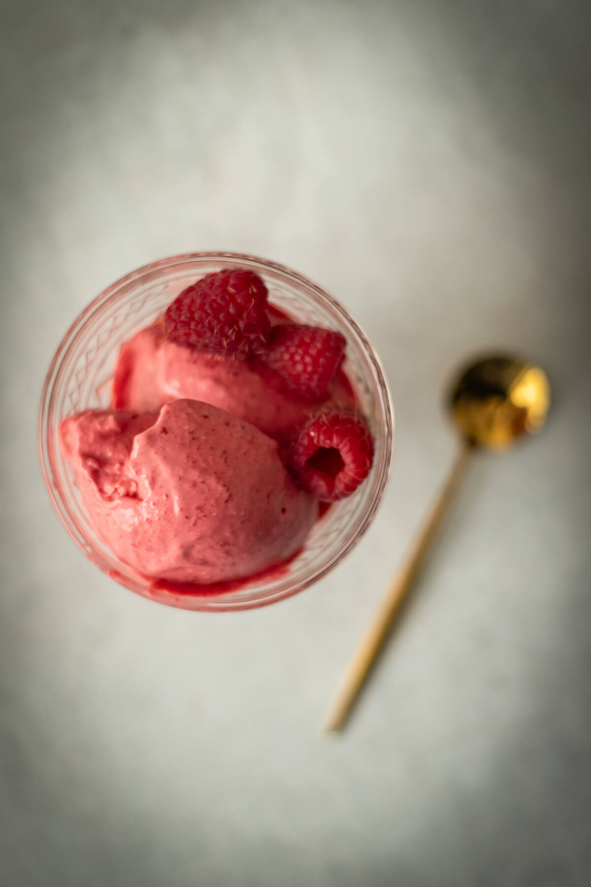 3 ingredient raspberry ice cream in a bowl with a gold spoon